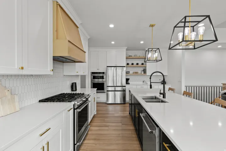 Contemporary kitchen featuring a gas range, stainless steel appliances, and a wood-finish floor