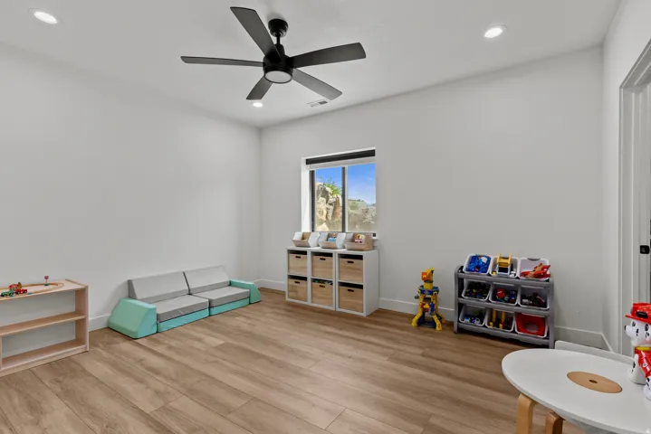 Spacious room featuring wood-finish flooring, recessed lighting, and a modern ceiling fan