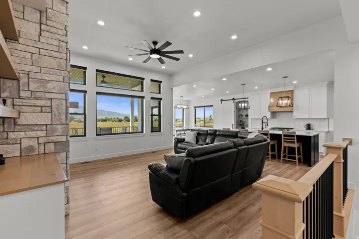 Expansive open-concept living space featuring wood-finish flooring and a stone accent wall