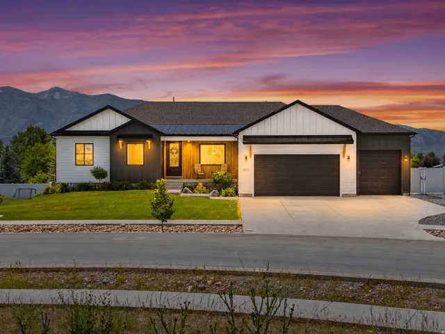 Modern ranch-style exterior featuring a striking blend of white vertical siding and dark horizontal siding