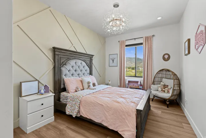 Feature wall with geometric wood paneling, wood-finish flooring, and a contemporary chandelier