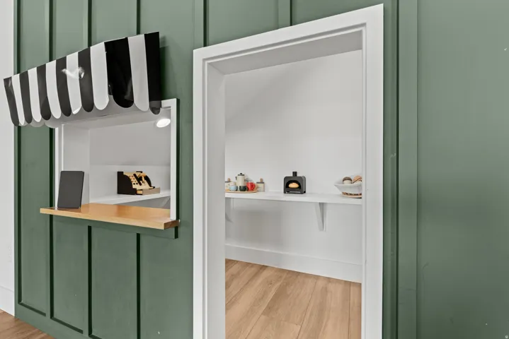 Play house with built-in merchant window featuring a striped awning and an interior light