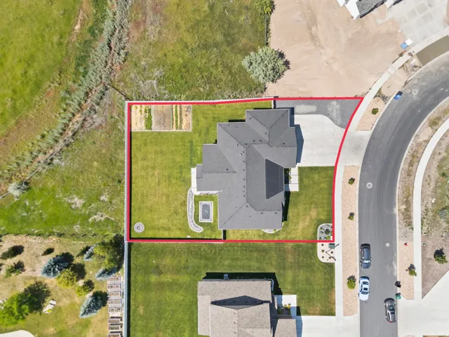 Aerial view showcasing a property with a distinct dark-tiled roof and solar panel installation