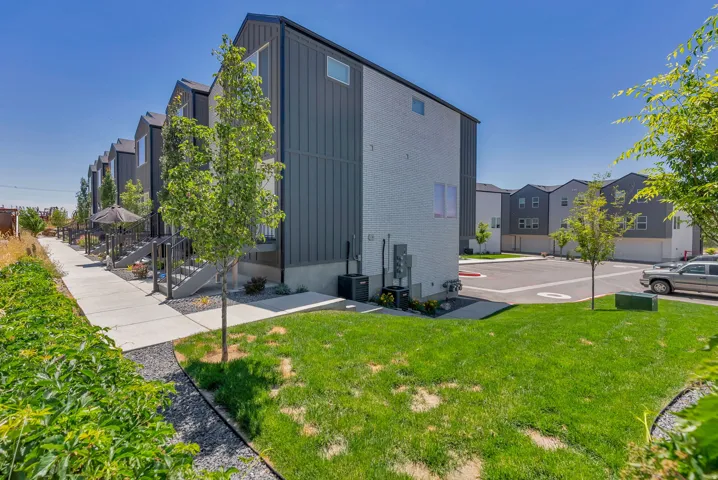 Modern townhome exterior featuring vertical metal siding and light-colored brick accents