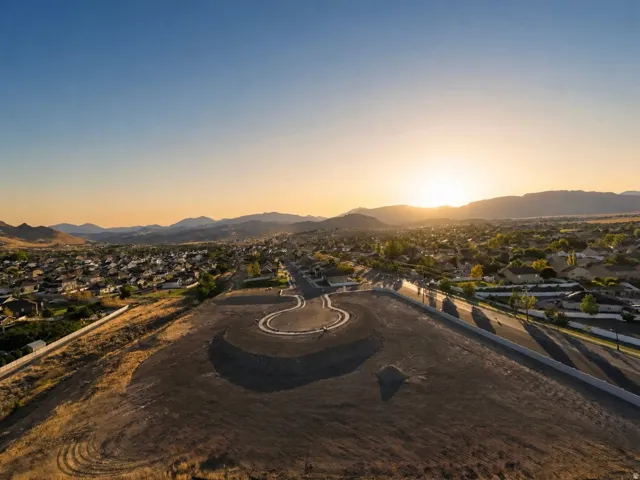 Expansive undeveloped land, graded for future construction, with paved roadways and utilities