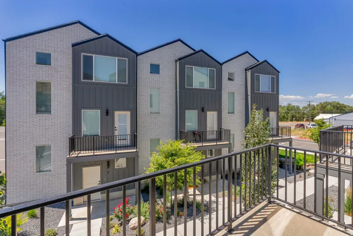 Contemporary townhome exterior featuring light-colored brick and dark vertical siding