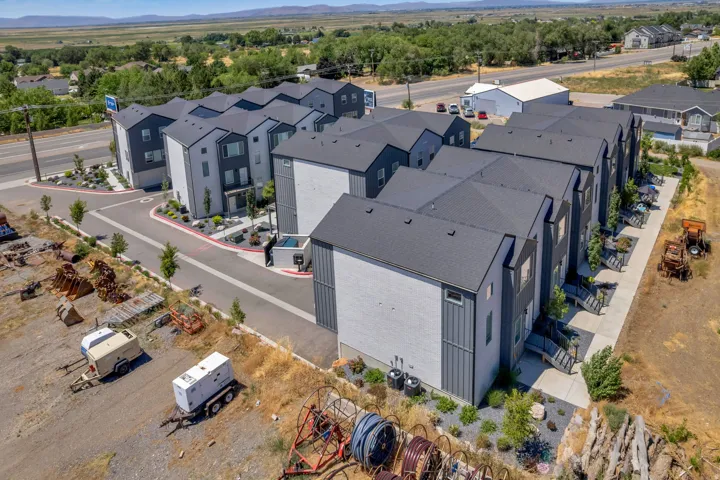 Contemporary townhome exteriors featuring multi-toned siding, dark roofs, and individual entrances