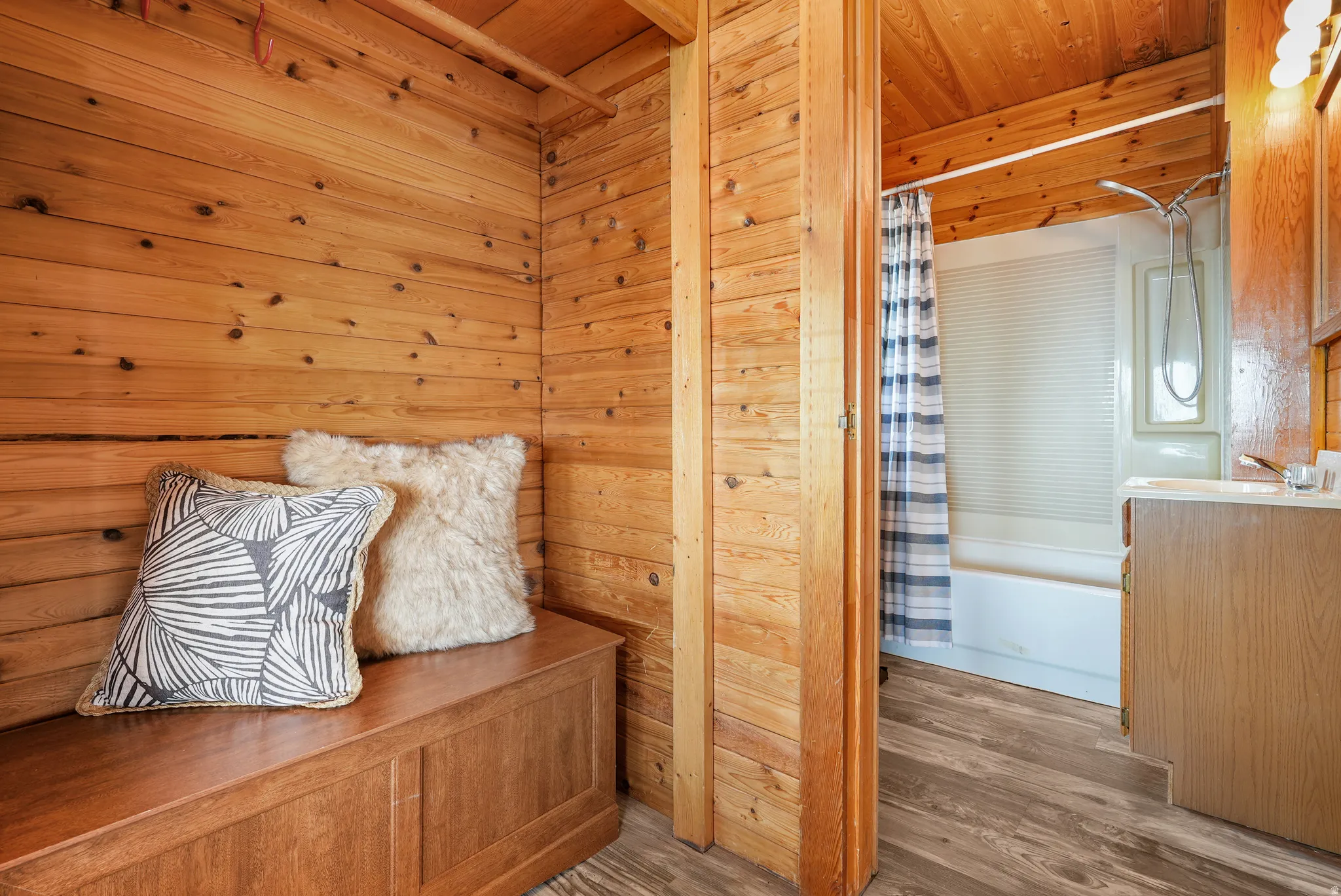 Warm wood paneling throughout, featuring a built-in wooden storage bench
