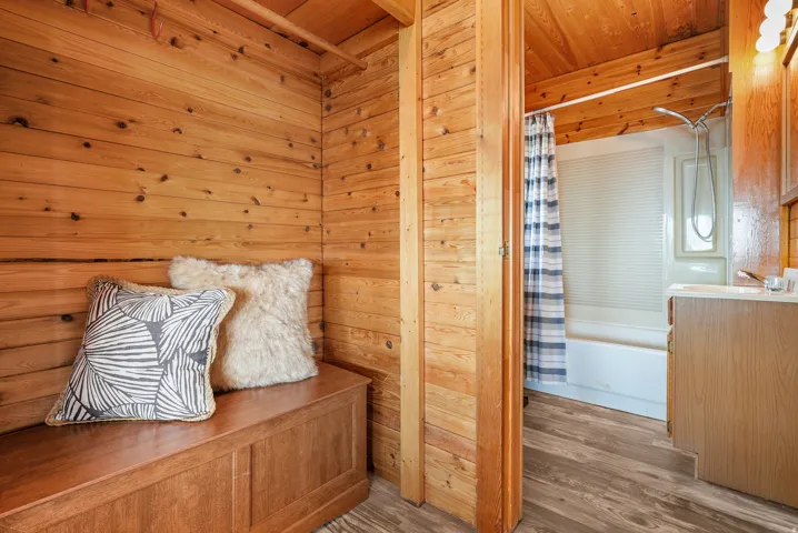 Warm wood paneling throughout, featuring a built-in wooden storage bench