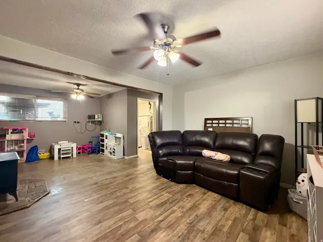Spacious interior featuring wood-finish flooring, two ceiling fans, and neutral wall tones