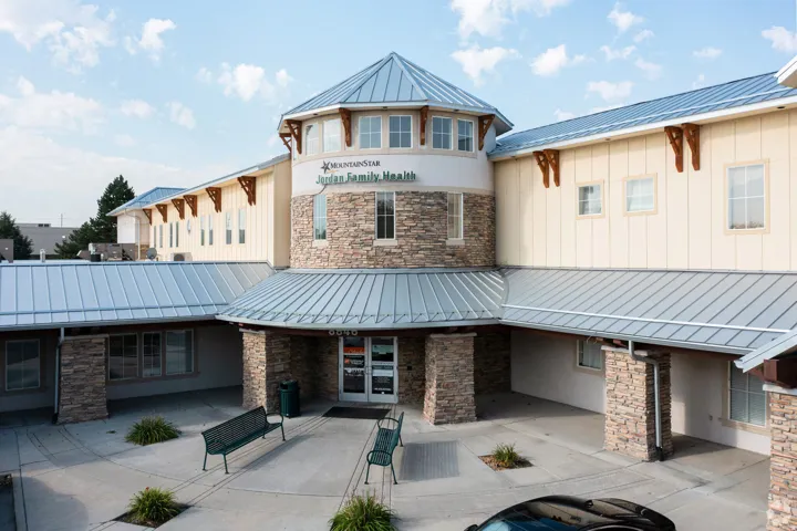 Exterior facade featuring stacked stone accents, horizontal siding, and multiple windows