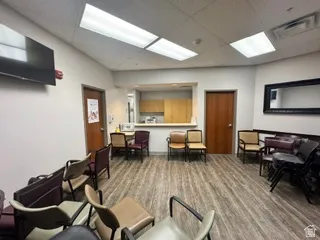 Waiting area featuring wood-finish flooring, recessed lighting, and a service counter with built-in cabinetry