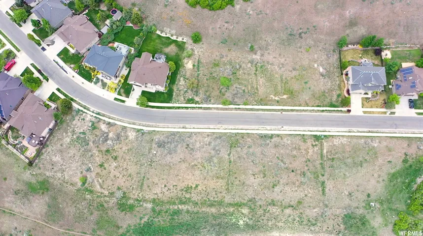 Expansive undeveloped land parcel featuring existing street frontage with curb and sidewalk infrastructure