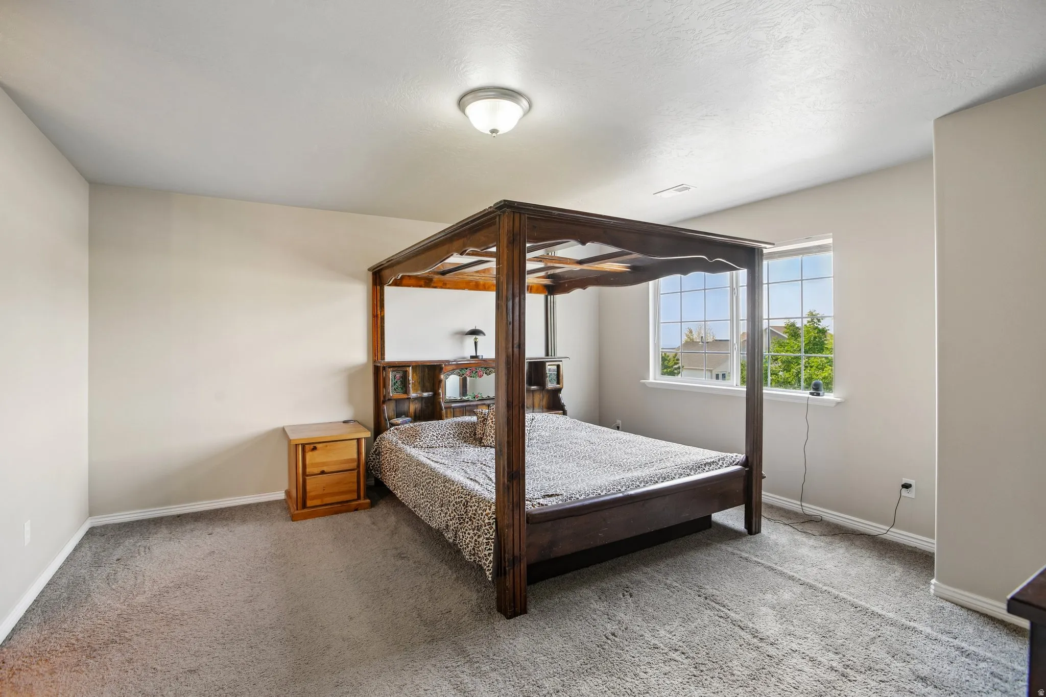 Carpeted room featuring neutral-toned walls, a double window with grid panes, and a flush mount ceiling light fixture