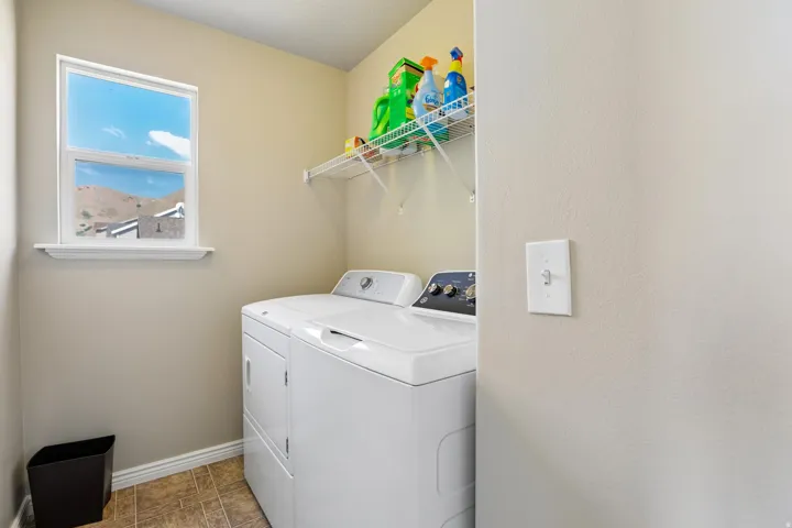 Dedicated utility room featuring neutral wall paint, a single window, and a built-in wire shelving unit