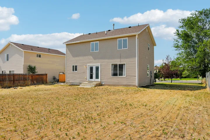 Rear exterior with beige horizontal siding and a brown shingle roof