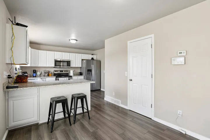 Kitchen featuring white cabinetry, light-toned countertops, and stainless steel appliances