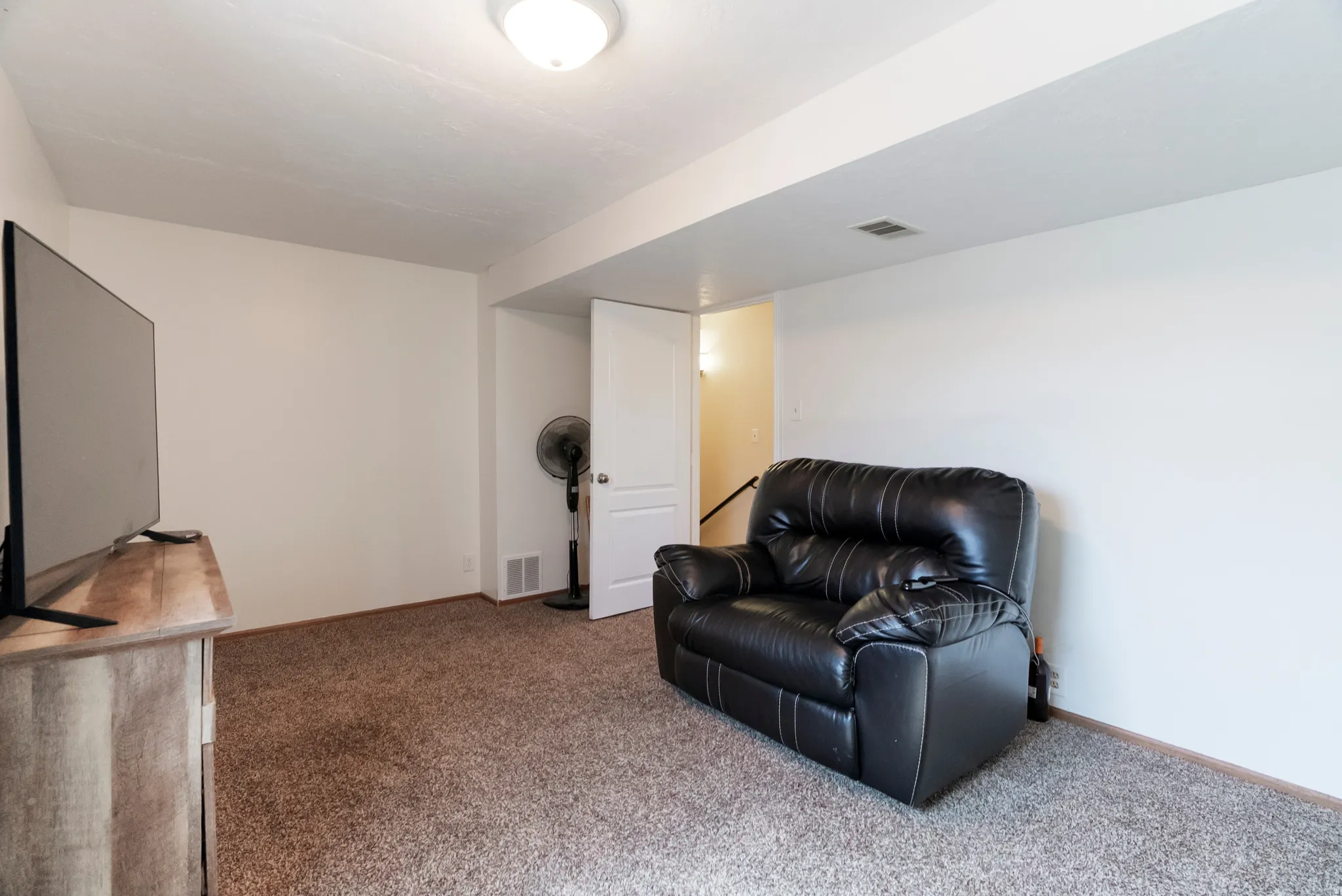 Carpeted room with white walls and a white ceiling