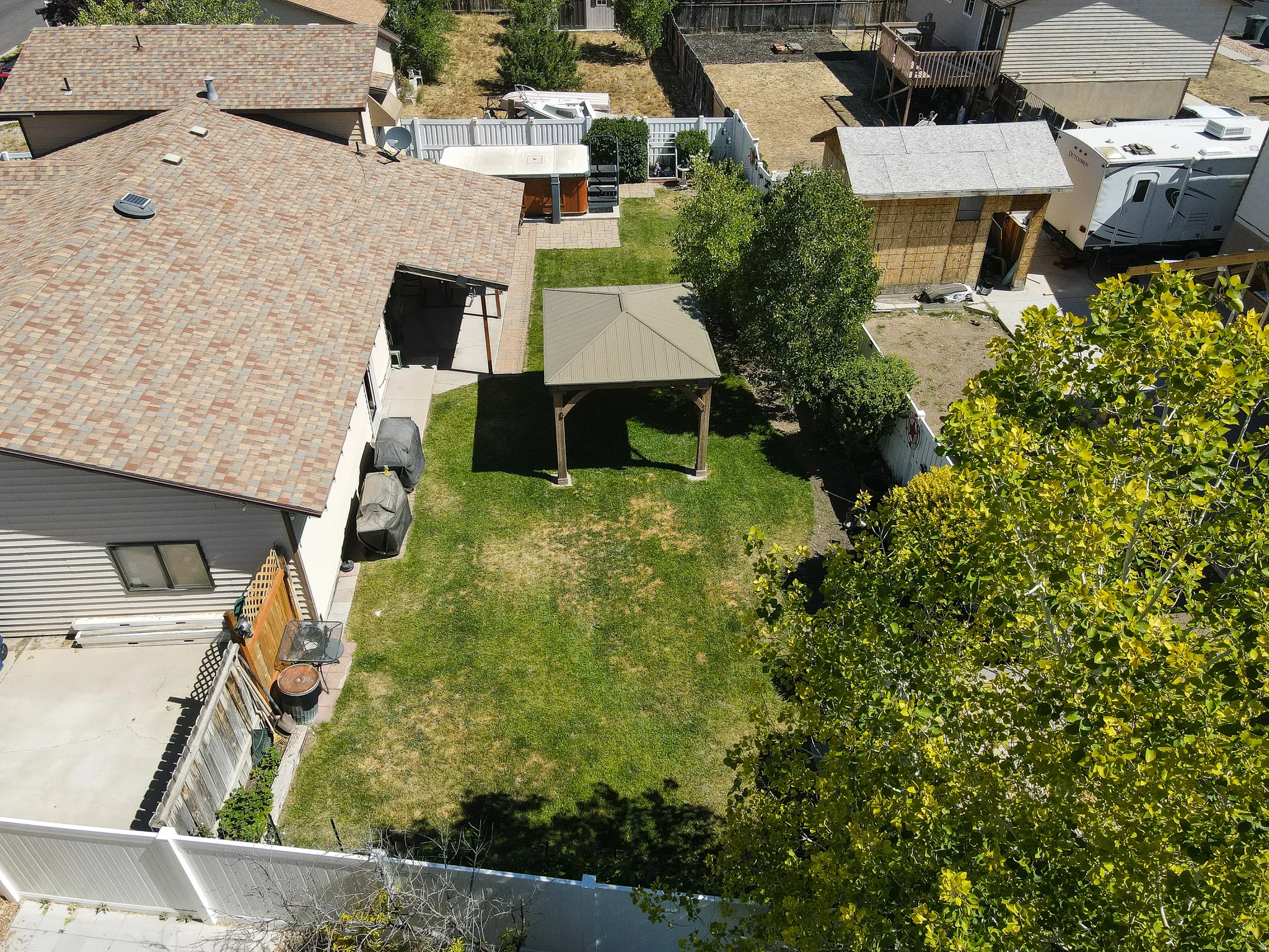 Expansive green lawn featuring a central gazebo structure and a concrete patio space