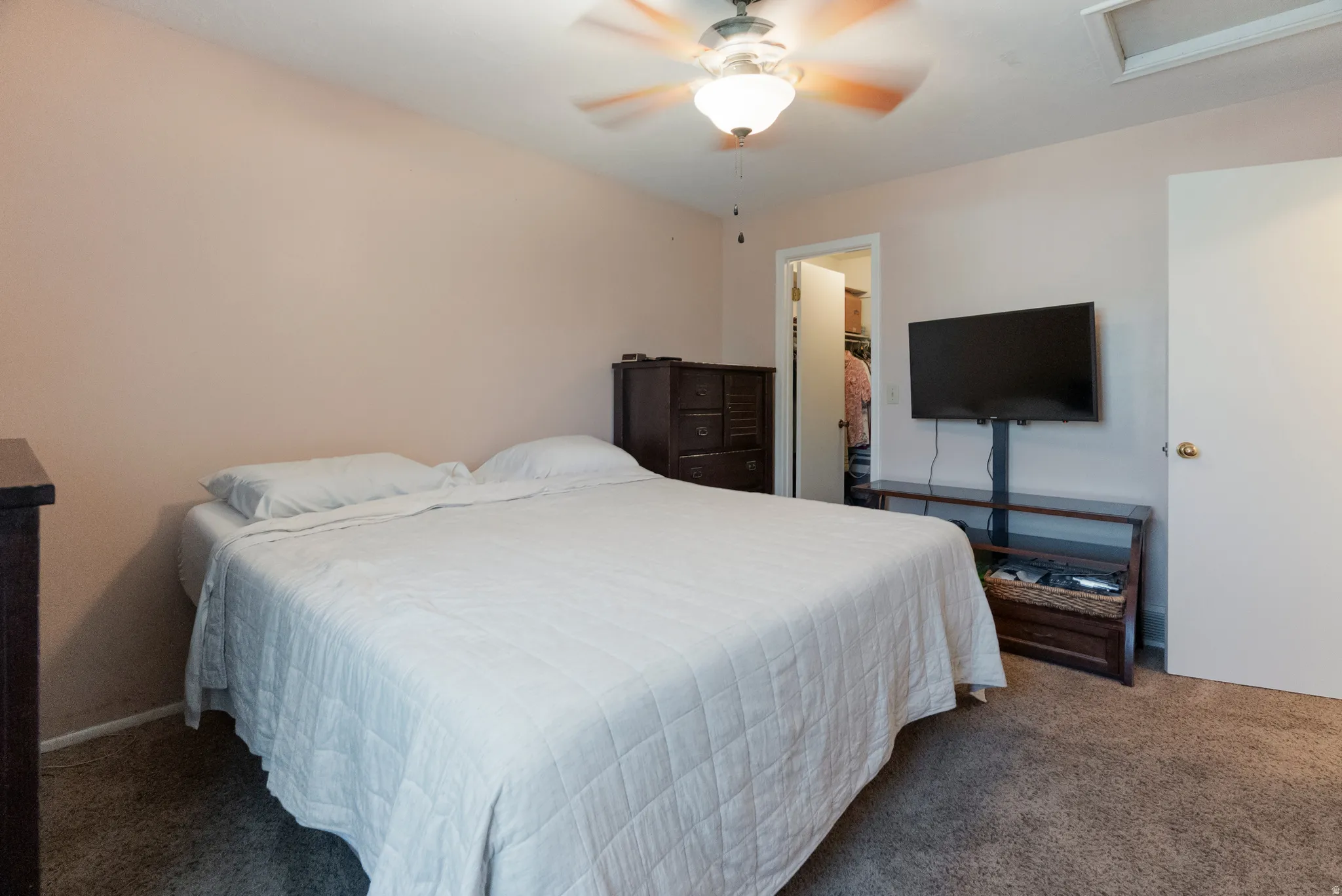Bedroom featuring neutral wall paint, ceiling fan with integrated lighting, and carpet flooring