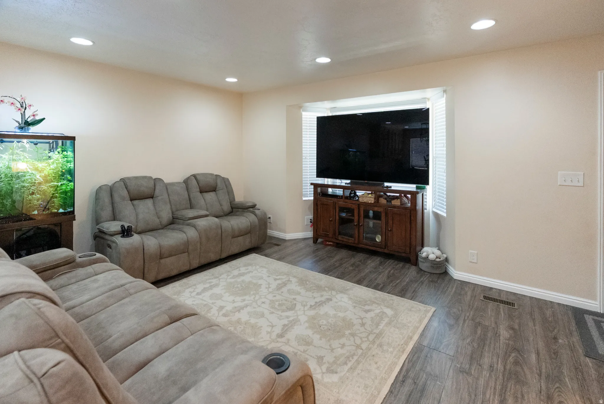 Living area featuring recessed lighting, wood-finish flooring, and a bay window