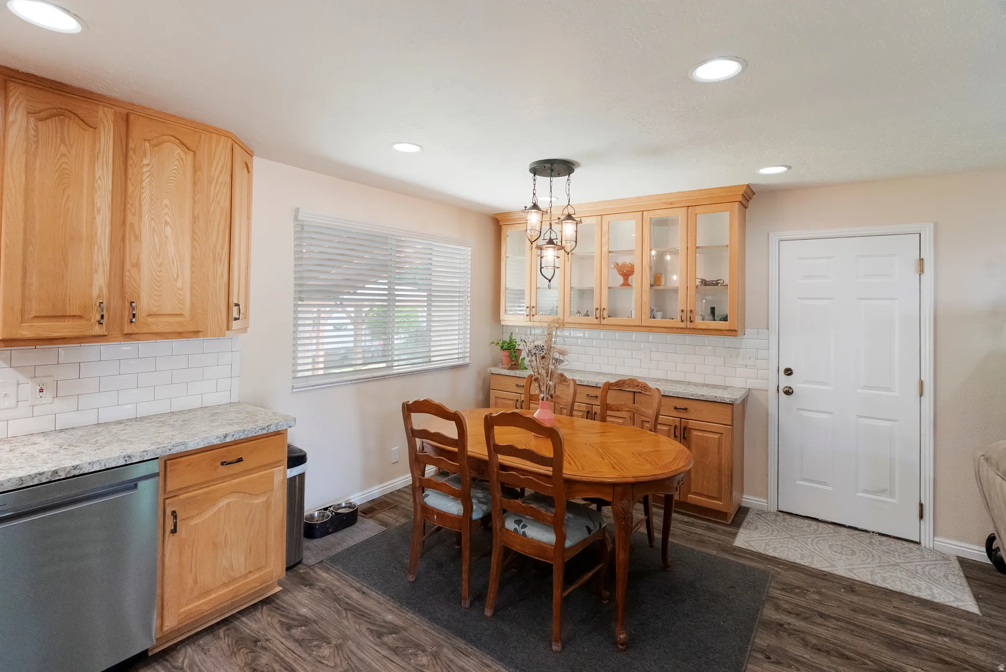 Kitchen and dining area featuring wood-finish flooring, recessed lighting, and a multi-light pendant fixture