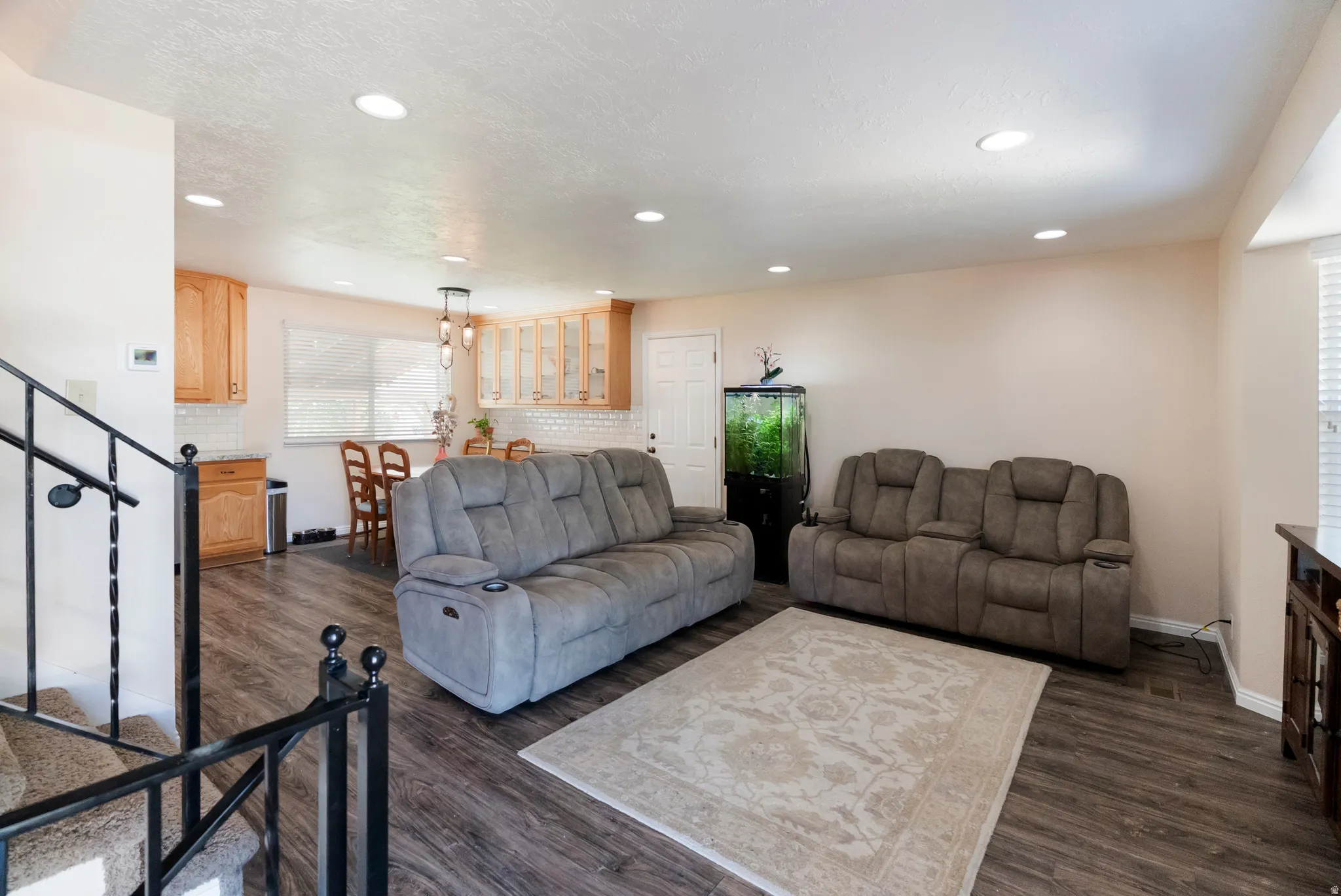 Open-concept living space featuring wood-finish flooring and recessed lighting