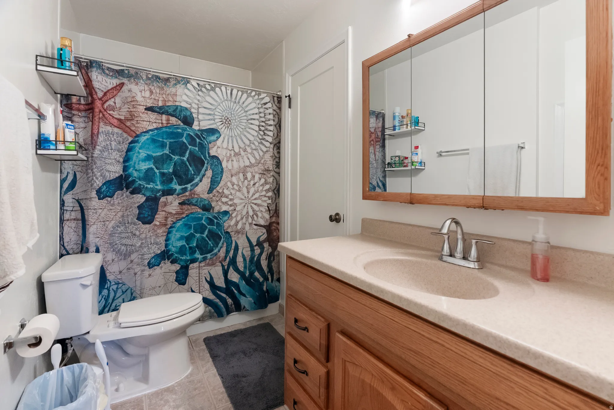 Bathroom featuring a vanity with a light-toned countertop, an undermount sink, and a chrome faucet