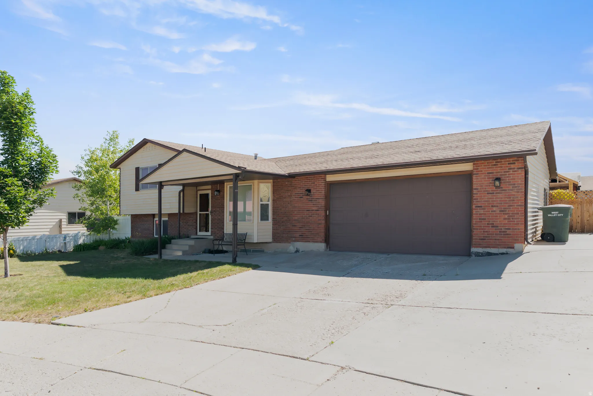 Brick and siding exterior featuring a covered entryway with concrete steps