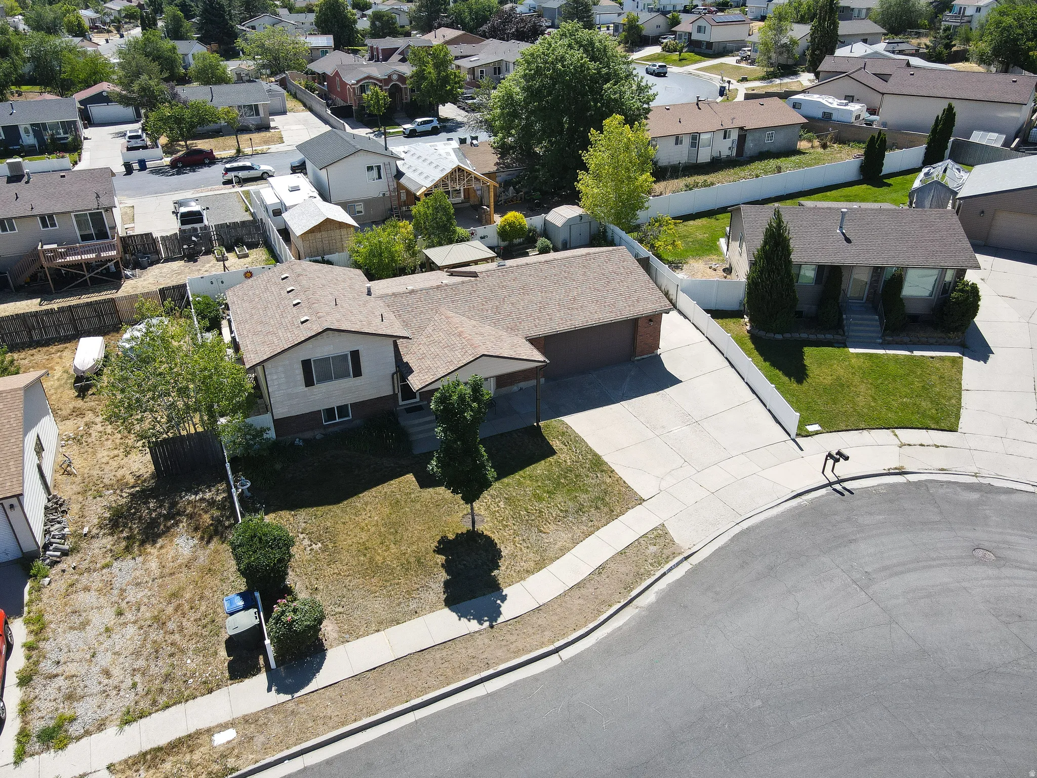 Split-level residence featuring a two-car garage, concrete driveway, and front lawn