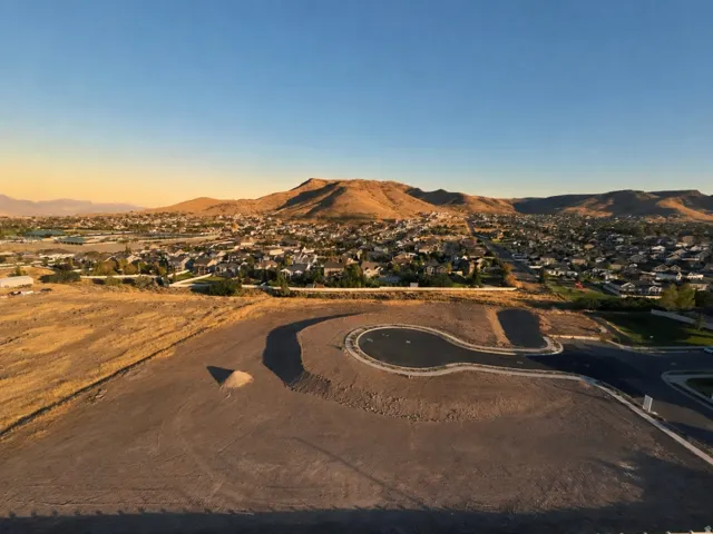 Expansive vacant lot with a newly paved cul-de-sac and mountain backdrop