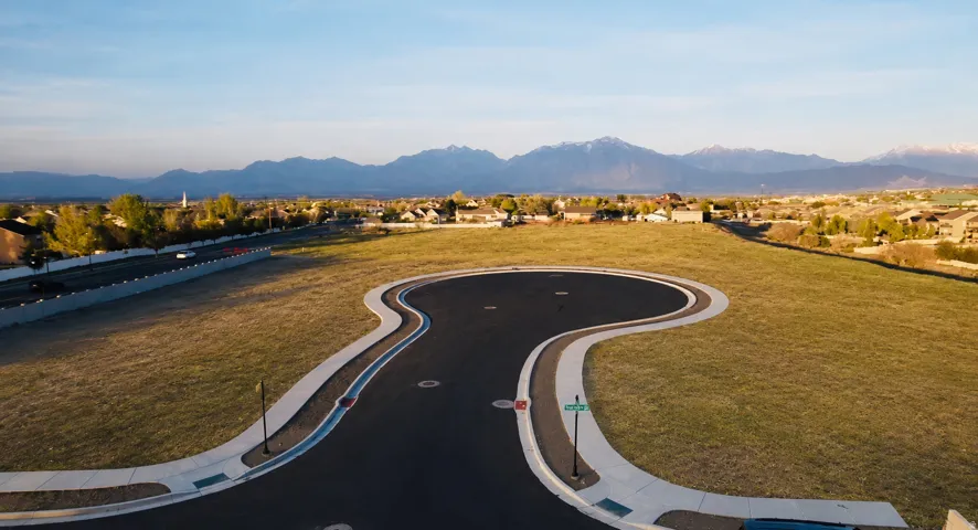 Expansive undeveloped land parcel featuring a paved cul-de-sac and mountain backdrop