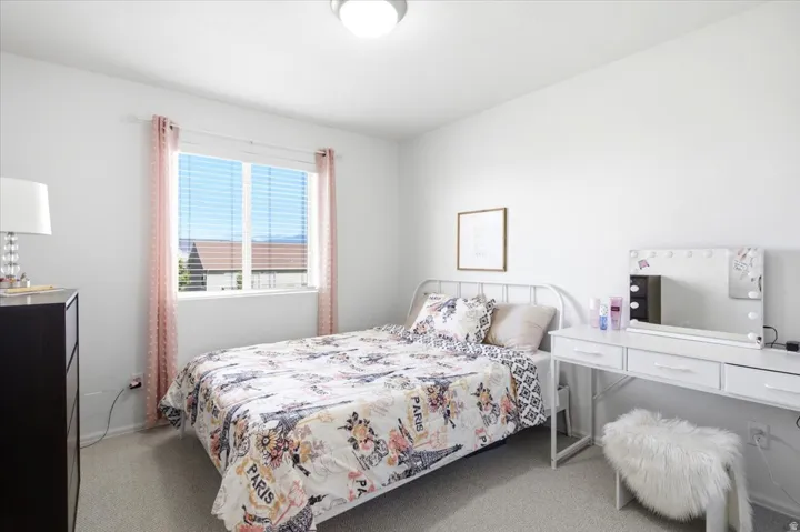 Light-filled room featuring a broad window with horizontal blinds, neutral wall paint, and recessed lighting