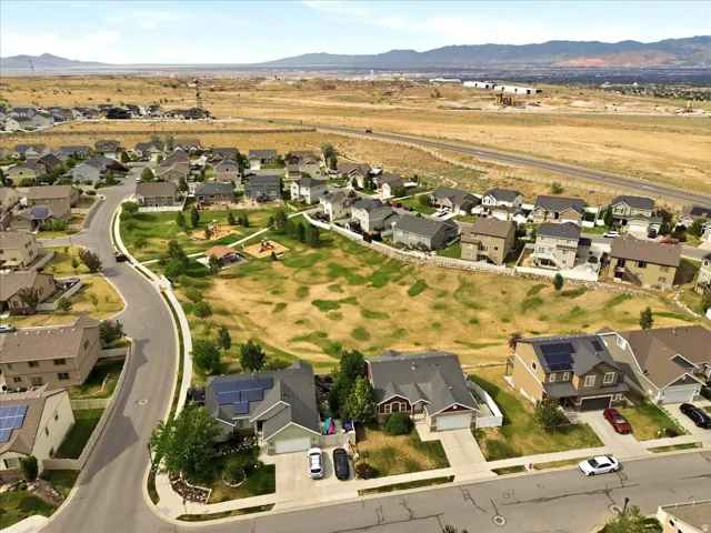 Residential neighborhood featuring paved streets and a central green space with playground equipment