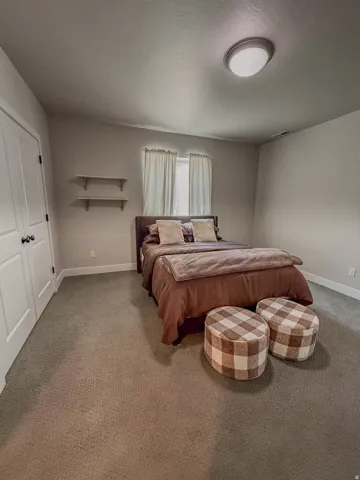 Bedroom featuring neutral-toned carpeting, light gray wall paint, and white trim