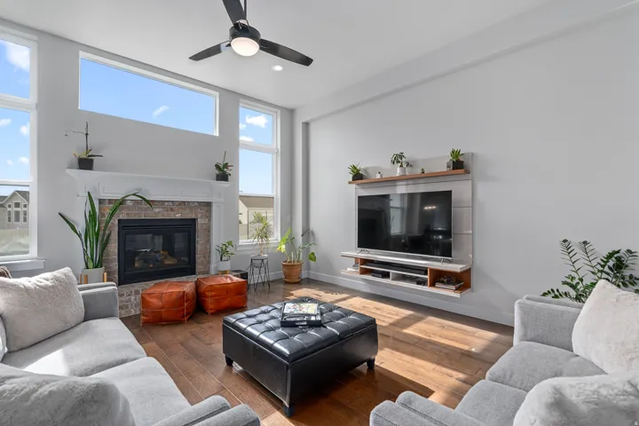 Living area with recessed lighting, plenty of natural light, a brick fireplace, dark wood finished floors, and ceiling fan