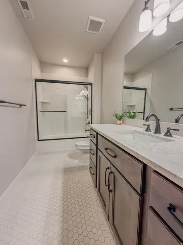 Bathroom featuring a dark wood-finish vanity with a light countertop, dual undermount sinks, and matte black fixtures