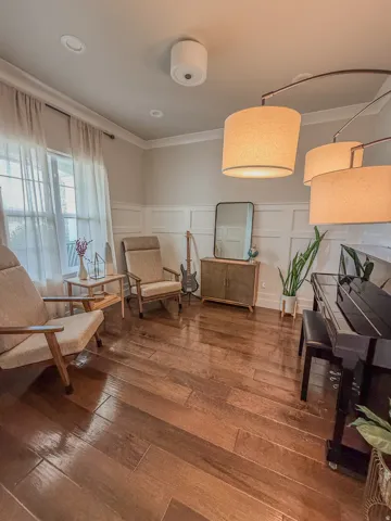 Second living  room space featuring wood-finish flooring, wainscoting, crown molding, and recessed lighting.