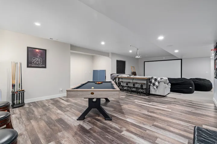 Recreation room featuring wood-finish flooring, recessed lighting.