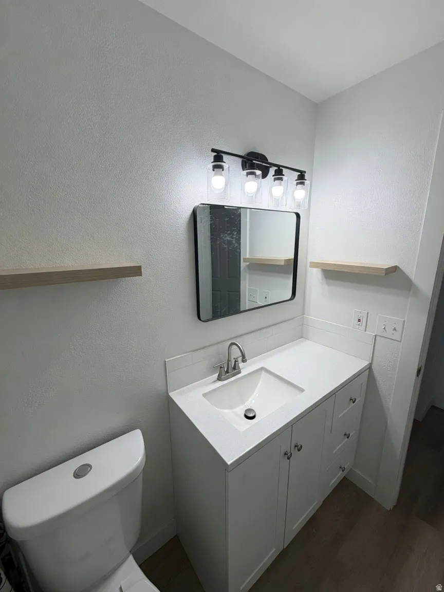 Contemporary bathroom featuring a white vanity with integrated sink, brushed nickel faucet, and a sleek black framed mirror