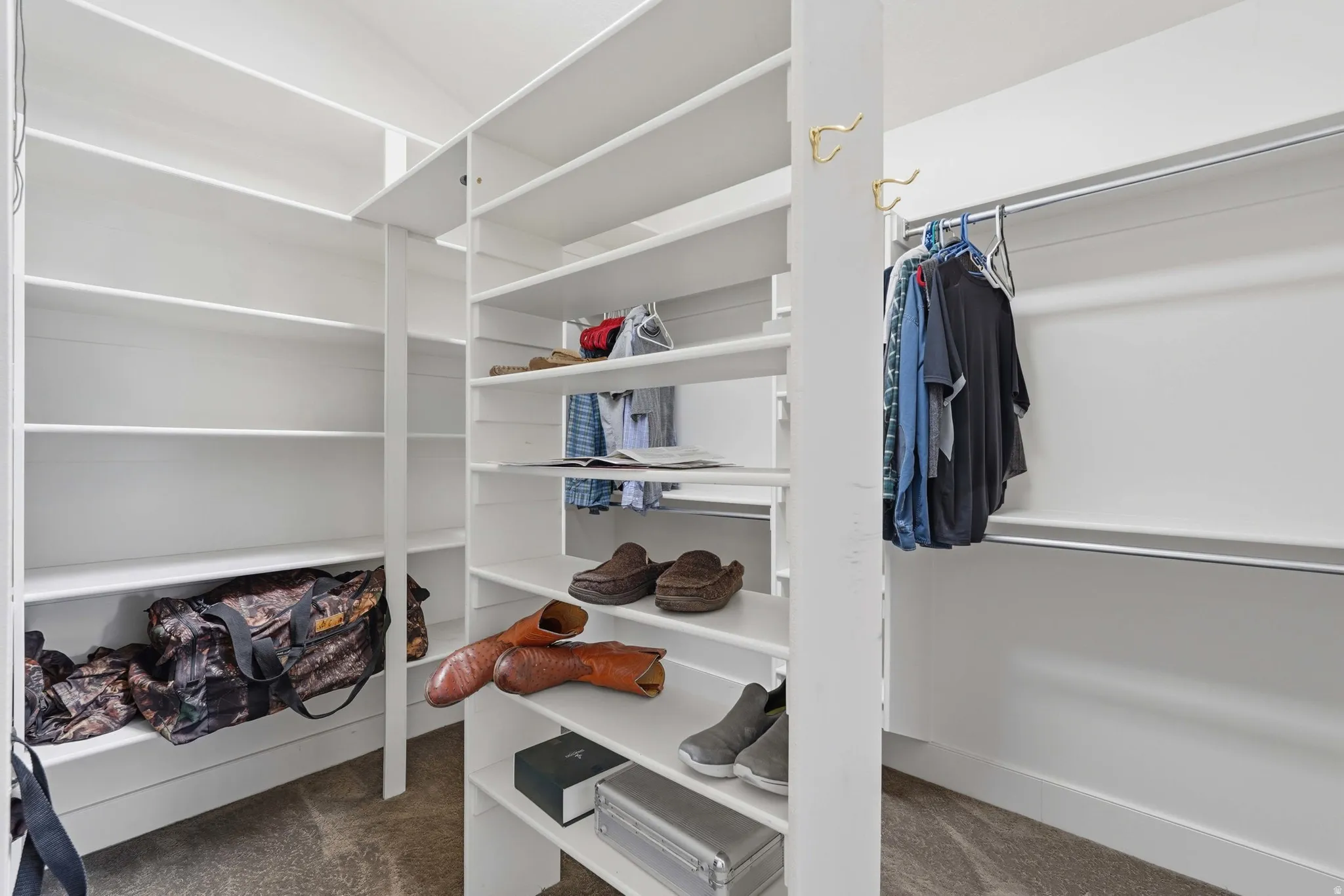 Walk-in closet featuring extensive built-in shelving, multiple hanging rods, and integrated storage solutions