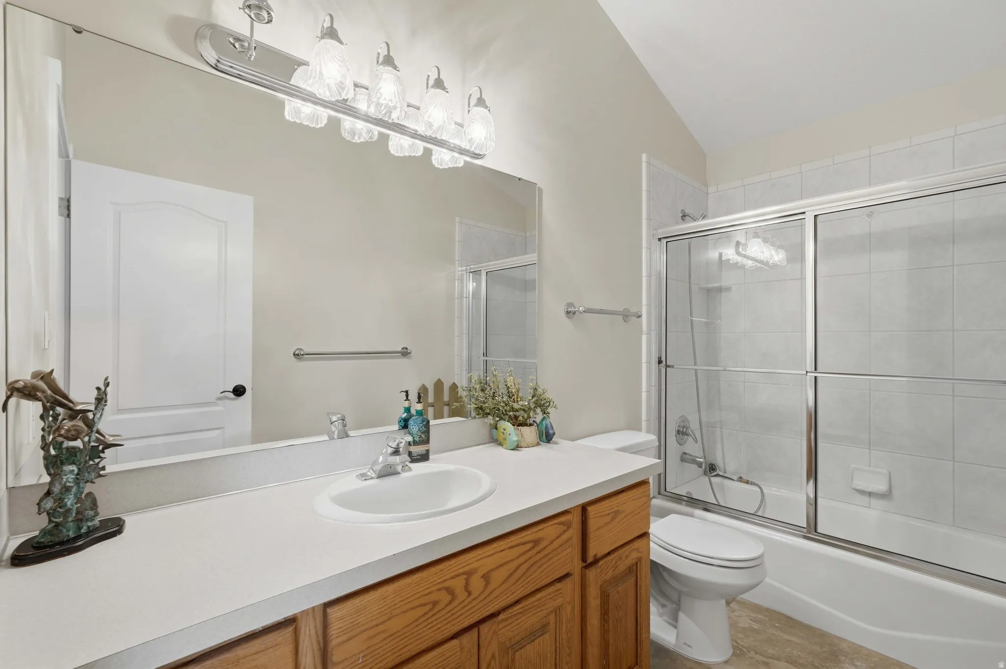 Bathroom featuring a wood-finish vanity with a white countertop and integrated sink