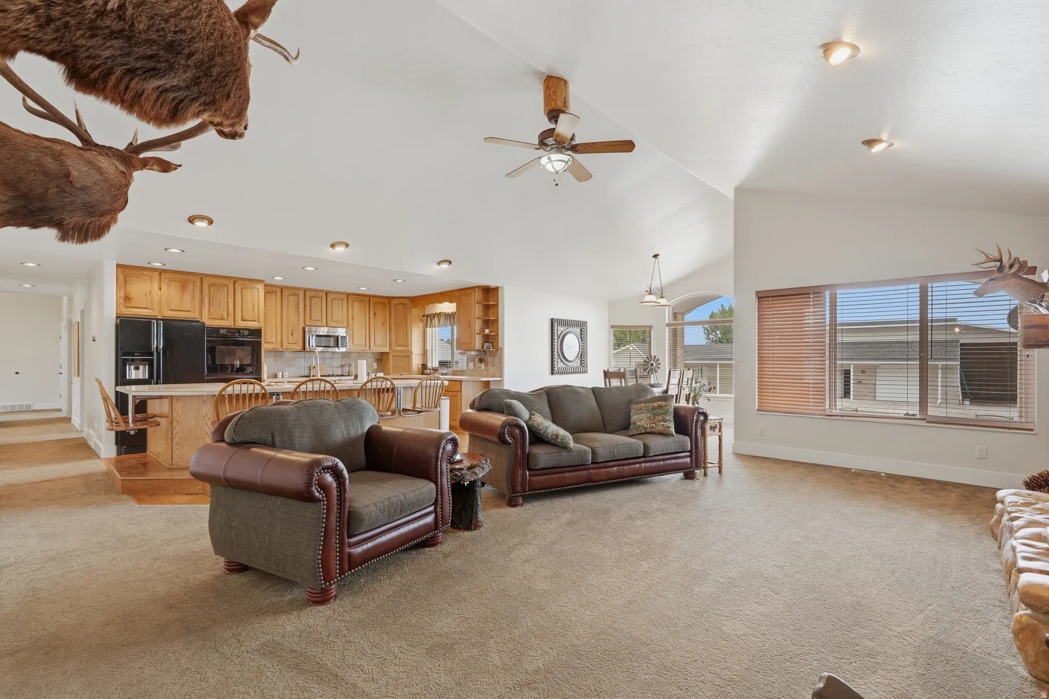 Expansive living area featuring vaulted ceilings, recessed lighting, and large windows