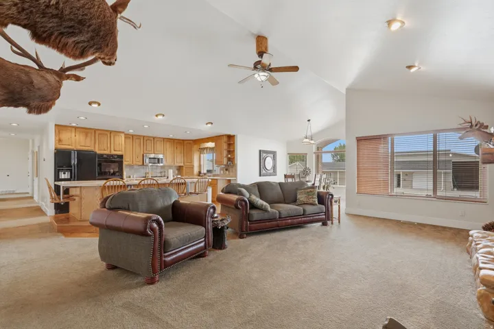 Expansive living area featuring vaulted ceilings, recessed lighting, and large windows