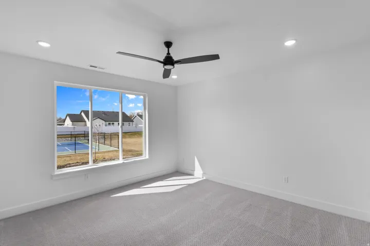 Bright room featuring a large window, recessed lighting, and a ceiling fan