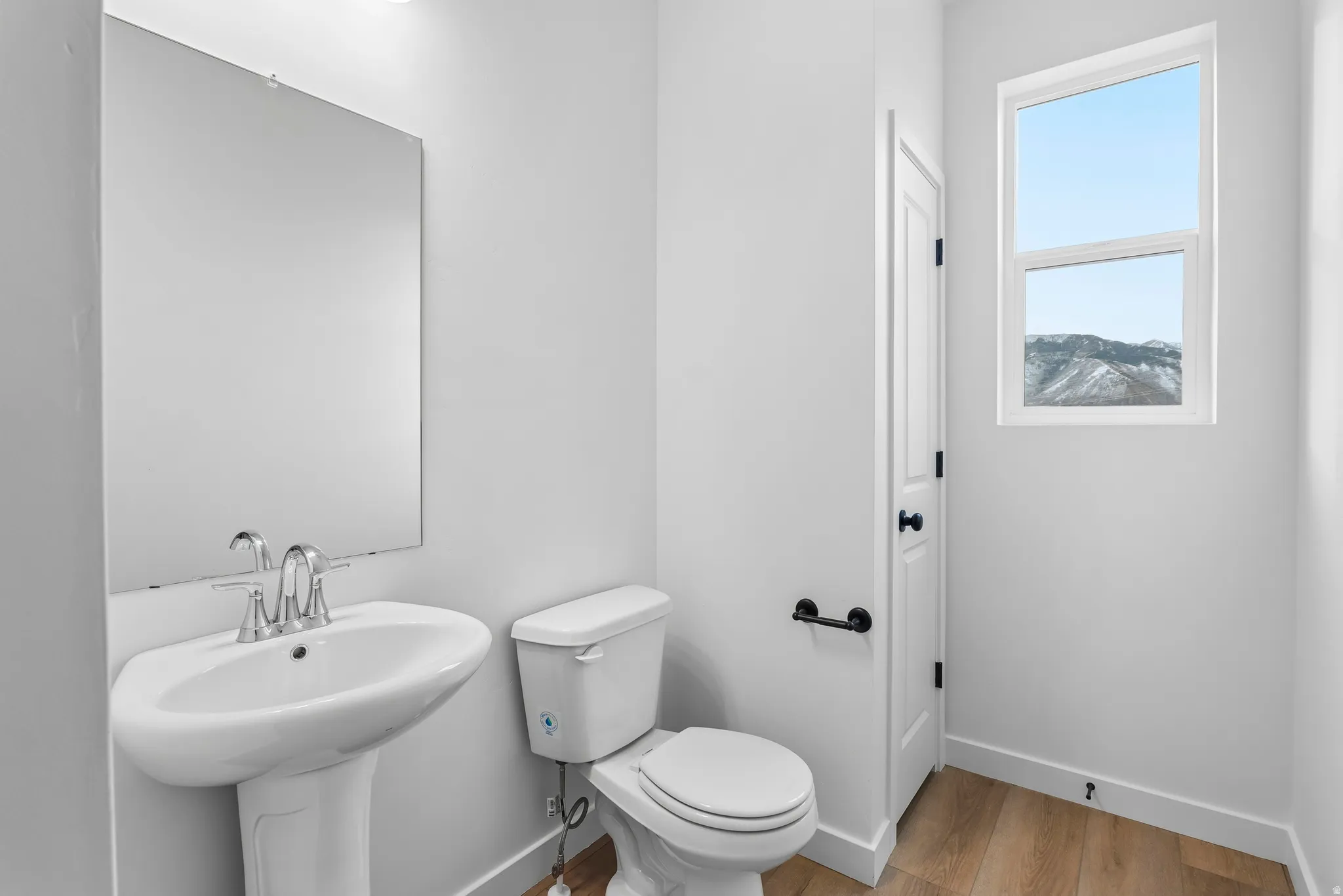 Pedestal sink with chrome faucet and rectangular mirror