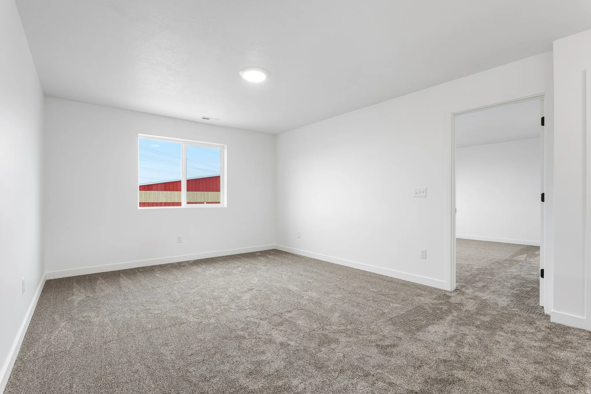 Spacious room featuring neutral carpet flooring and white walls
