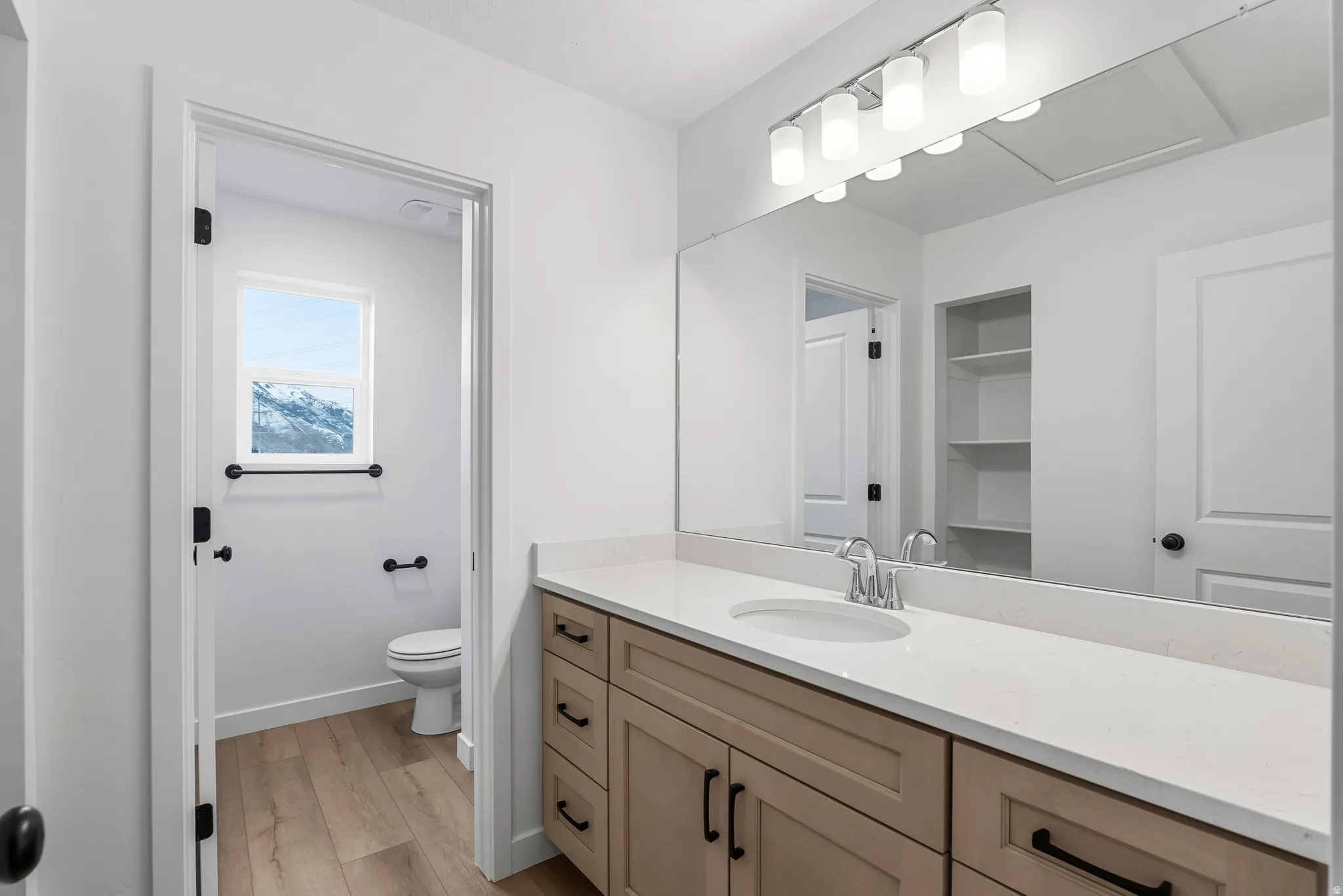 Bathroom featuring a light wood-finish vanity with a white countertop and integrated sink