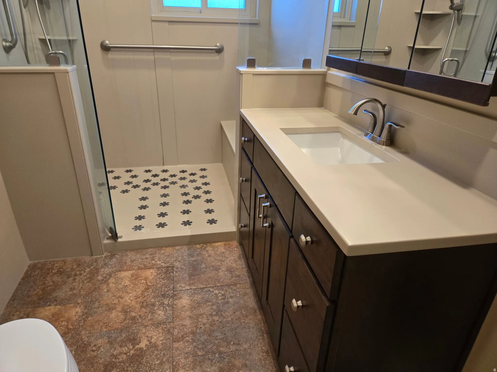 Modern vanity with an integrated sink, brushed nickel faucet, and a light-toned countertop