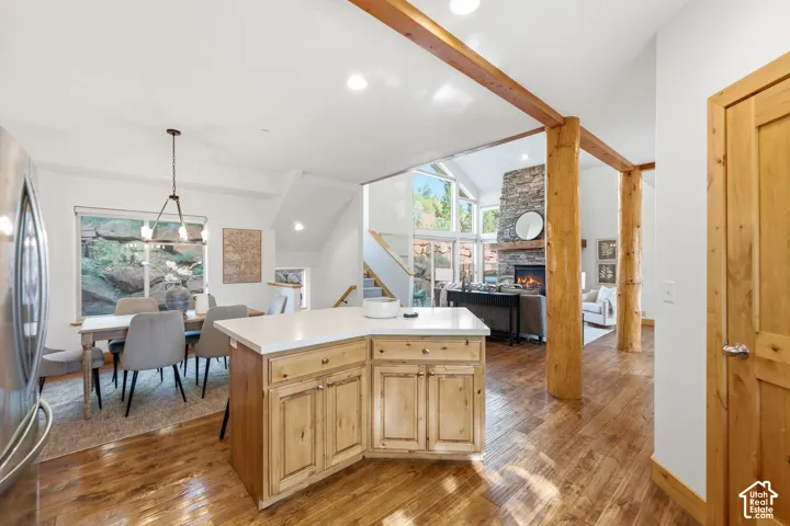 Open-concept living space with wood-finish flooring and exposed wood beams
